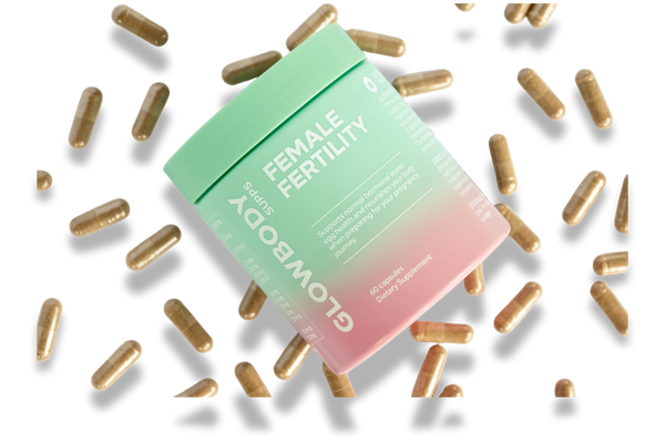 Glowbody Supps Female Fertility Supplement packaging surrounded by brown capsules on a white background. Female multi vitamin