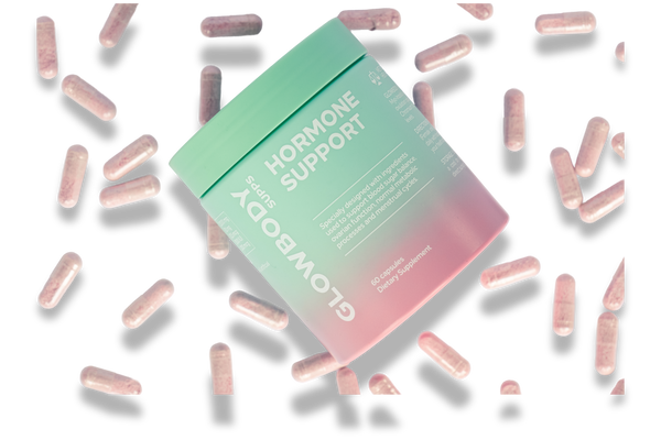 Glowbody Supps Hormone Support Supplement packaging surrounded by pink capsules on a white background. Female multi vitamin